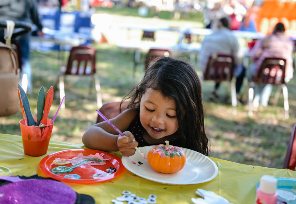 Audrey Burns paints a pumpkin at the Homecoming Festival. She is the daughter of Bobby Burns, defensive backs coach for Fighting Tiger Football. (Campbellsville University Photo by Joshua Williams)